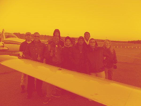 Frederick Douglass Academy students standing beside a light aircraft.