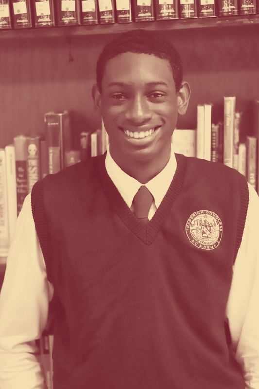 A Frederick Douglass Academy high school student wearing the white shirt, maroon tie and crested cardigan.
