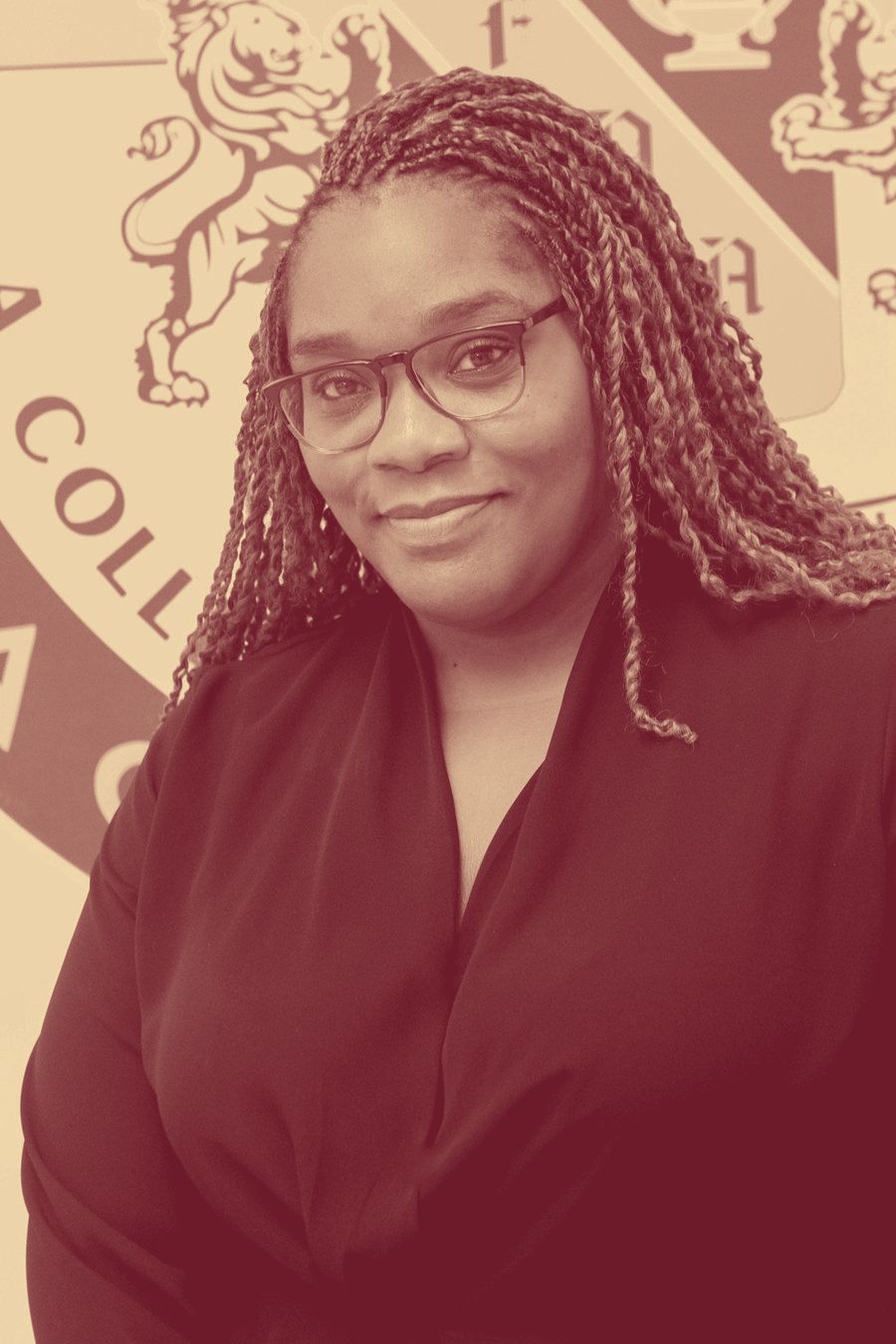 Principal Ayisha Fullerton, photographed in front of the Frederick Douglass Academy crest.